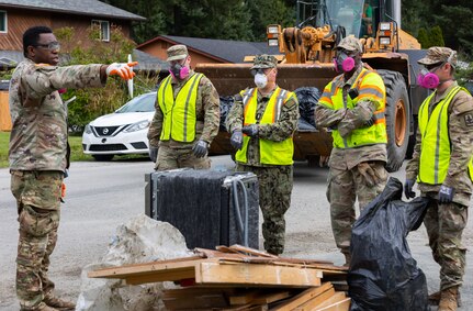 Service members with the Alaska Air, Army National Guard, and Naval Militia clear debris off the road while assisting local authorities and tribal emergency operations personnel in the Mendenhall Valley, Juneau, Alaska, Aug. 14, 2024.