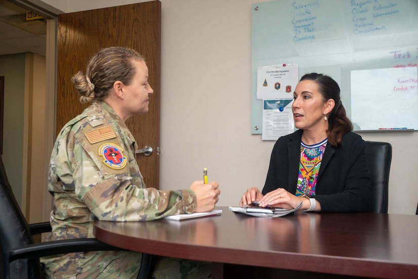 Two people sit at a table and talk.