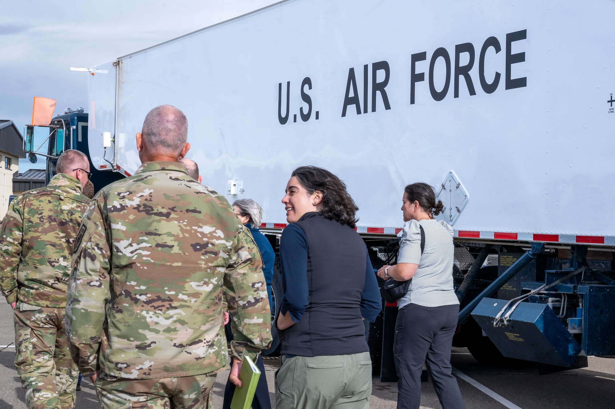 A group of people walk in front of a truck that says U.S. Air Force.