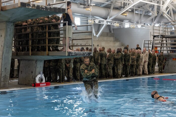 A U.S. Marine Corps recruit with Echo Company, 2nd Recruit Training Battalion, jumps off a tower during water survival training at Marine Corps Recruit Depot San Diego, California, Aug. 19, 2024. Recruits receive basic water survival training to prepare them for their swim qualification test. Basic water survival instructs recruits on how to execute basic water maneuvers and promotes combat readiness (U.S. Marine Corps photo by Lance Cpl. Jacob B. Hutchinson)