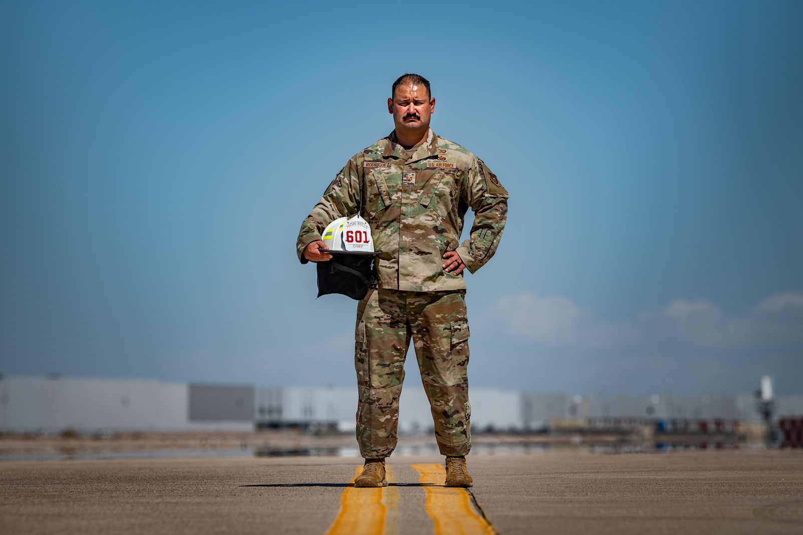 Reserve Citizen Airman Tech. Sgt. Orlando Rodriguez, senior enlisted leader for the 944th Operations Group Detachment 1 at Holloman Air Force Base, New Mexico, stands on the flight line with his firefighter helmet at Luke Air Force Base, Ariz., on Sept. 4, 2024. Rodriguez balances his Air Force duties with volunteer firefighting in his community. (U.S. Air Force photo by Tech. Sgt. Tyler J. Bolken)