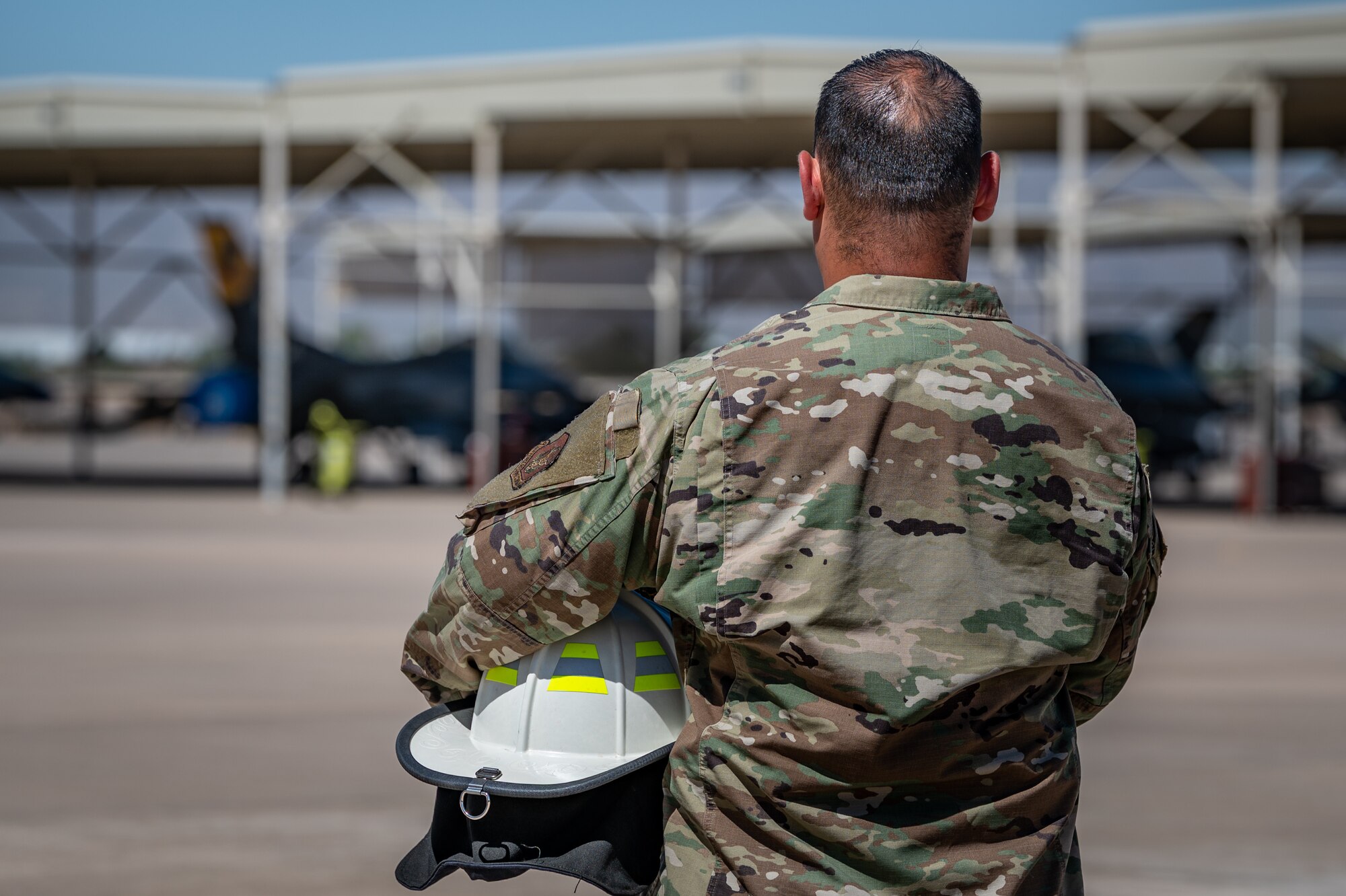 Reserve Citizen Airman Tech. Sgt. Orlando Rodriguez, senior enlisted leader for the 944th Operations Group Detachment 1 out of Holloman Air Force Base, New Mexico, holds his firefighter helmet while standing on the flight line at Luke Air Force Base, Ariz., on Sept. 4, 2024. Rodriguez transitioned to the Air Force Reserve from active-duty in 2019 and joined the locally assigned 944th OG Det 1 of the 944th Fighter Wing out of Luke AFB, Ariz. (U.S. Air Force photo by Tech. Sgt. Tyler J. Bolken)