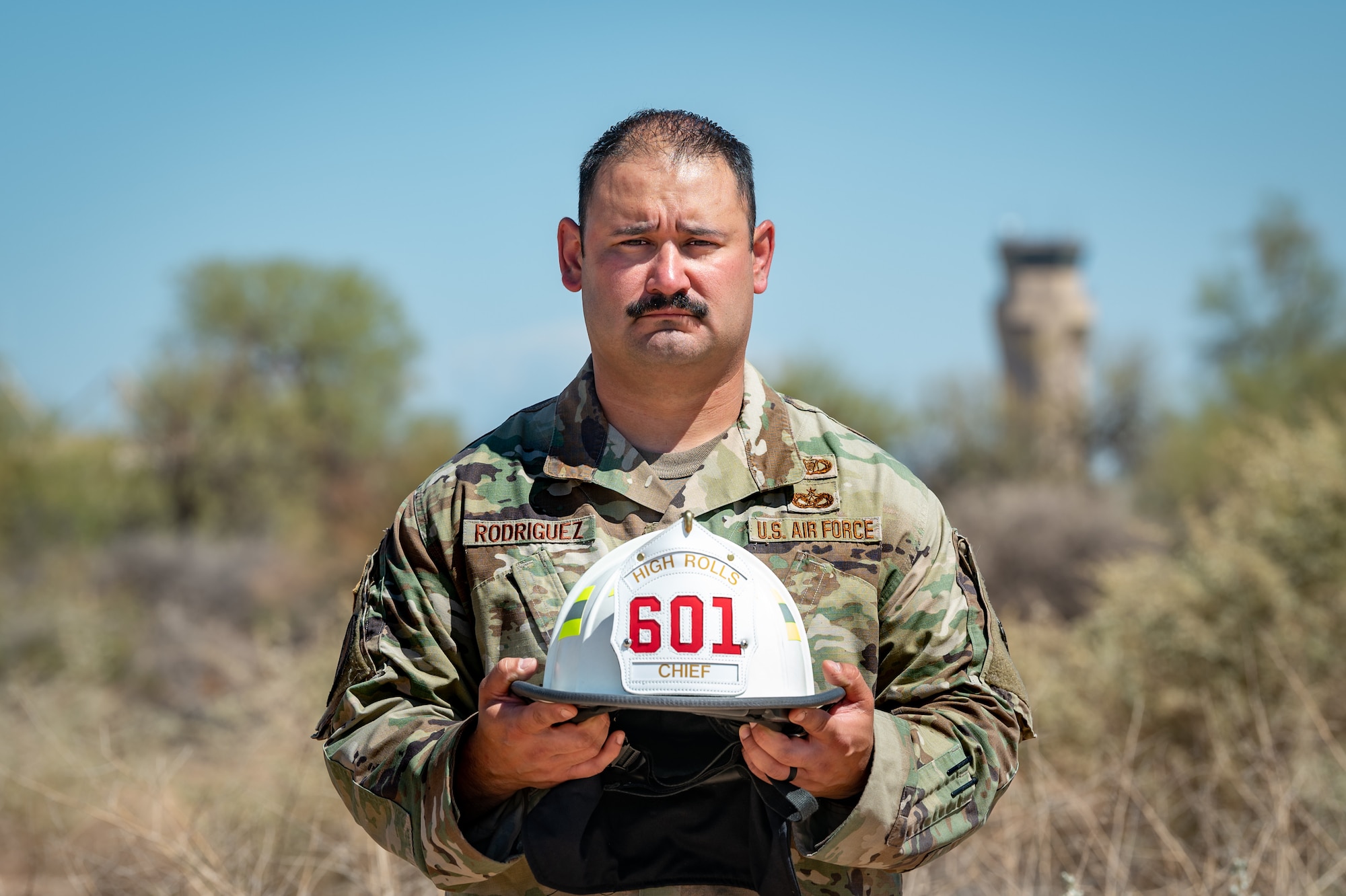 Reserve Citizen Airman Tech. Sgt. Orlando Rodriguez, senior enlisted leader for the 944th Operations Group Detachment 1 at Holloman Air Force Base, New Mexico, stands with his firefighter helmet at Luke Air Force Base, Ariz., on Sept. 4, 2024. Rodriguez volunteers as a firefighter in his local community, embodying his commitment to service both in and out of uniform. (U.S. Air Force photo by Tech. Sgt. Tyler J. Bolken)