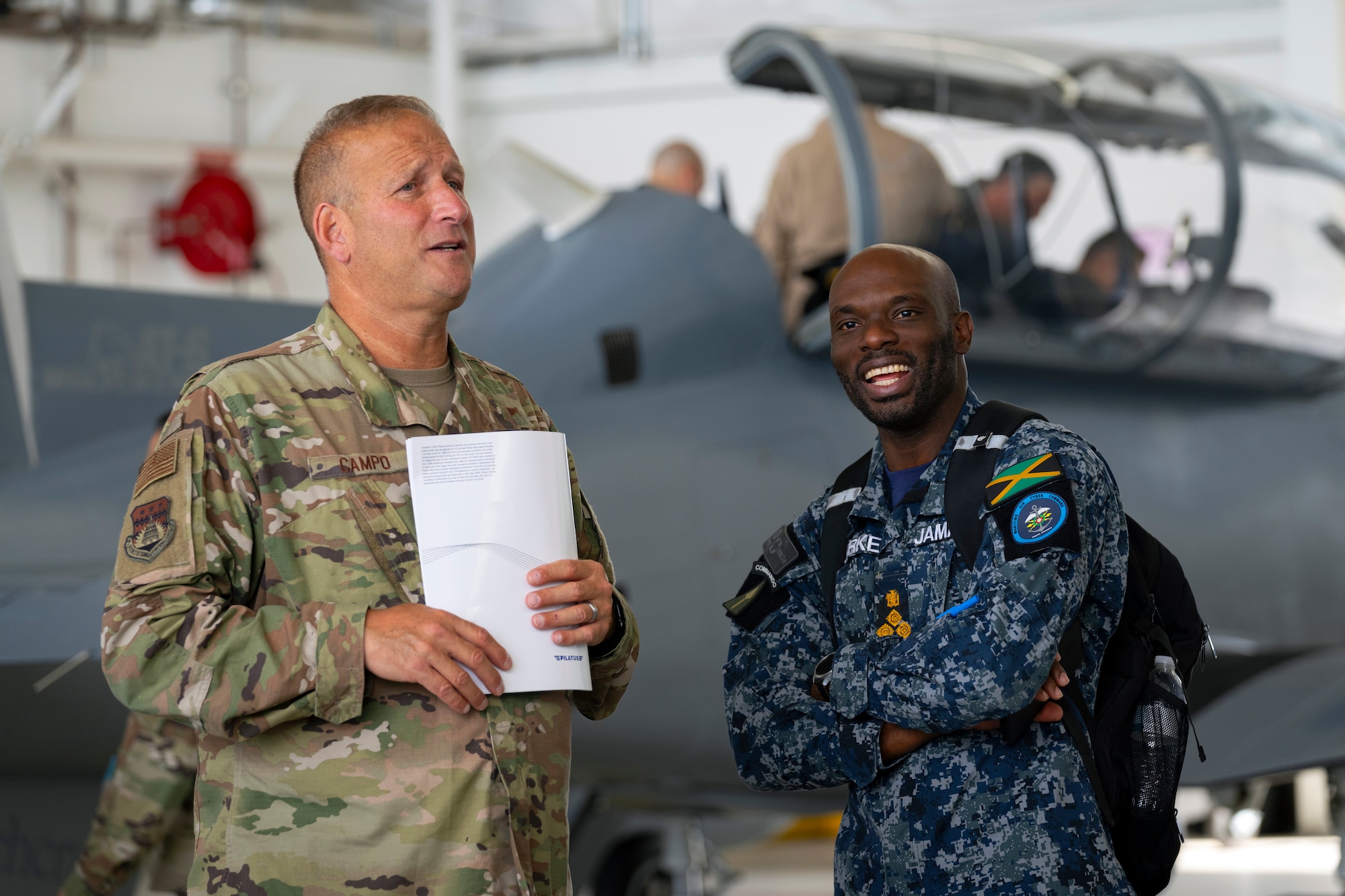 U.S. Air Force Brig. Gen. John Campo, director of the joint staff, District of Columbia National Guard, and Jamaican Defence Force Air Wing Brigadier Elon Clarke, Brigade commander, Air and Cyber Command, attend industry day at Davis-Monthan Air Force Base, Arizona, during the Central American and Caribbean Air Chiefs conference, Aug. 27, 2024. The week-long conference united key air force leaders from 13 Central American and Caribbean partner nations to work collaboratively to address future challenges and share best practices. (U.S. Air Force photo by Tech. Sgt. Rachel Maxwell)