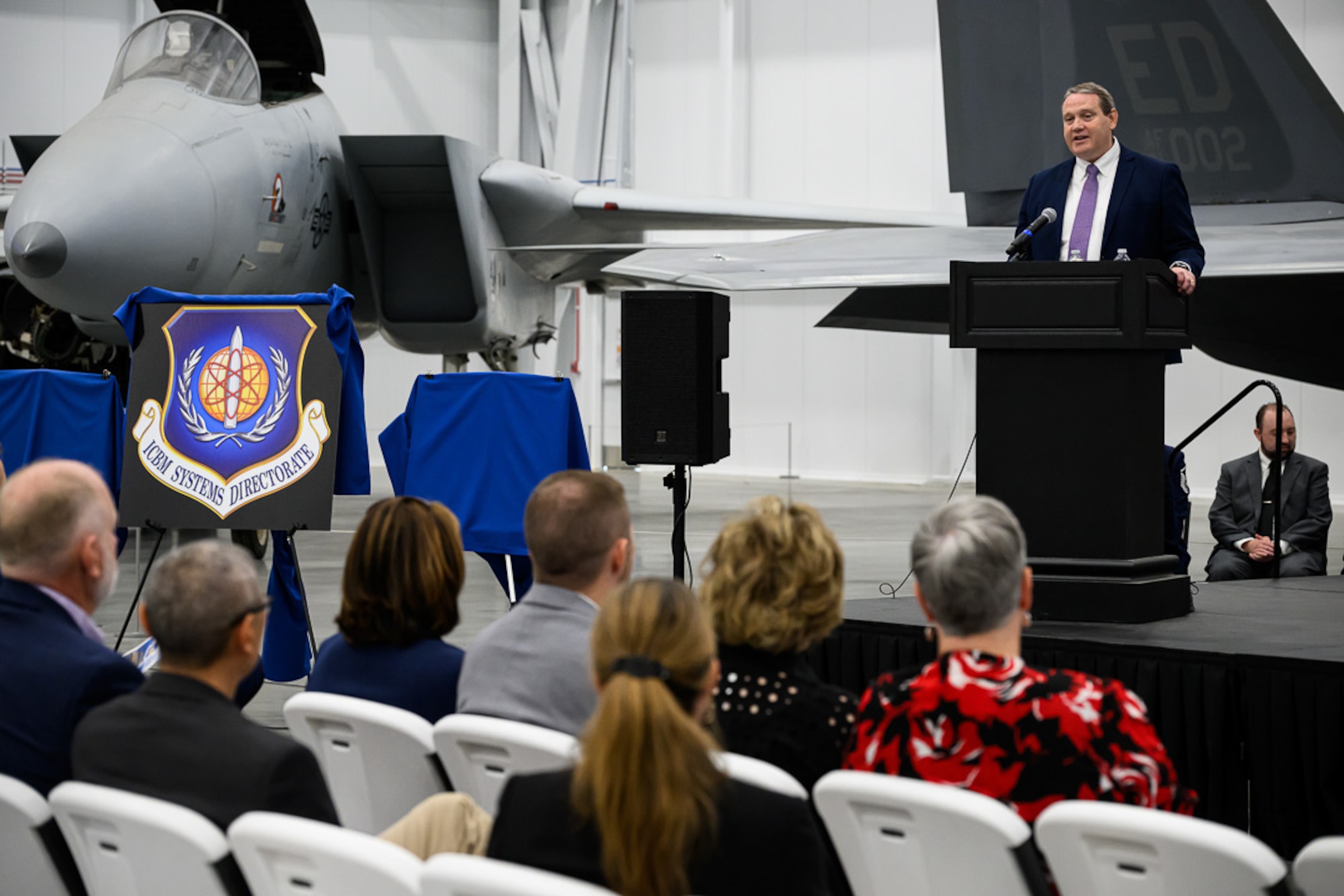 Man at lectern talks to audience
