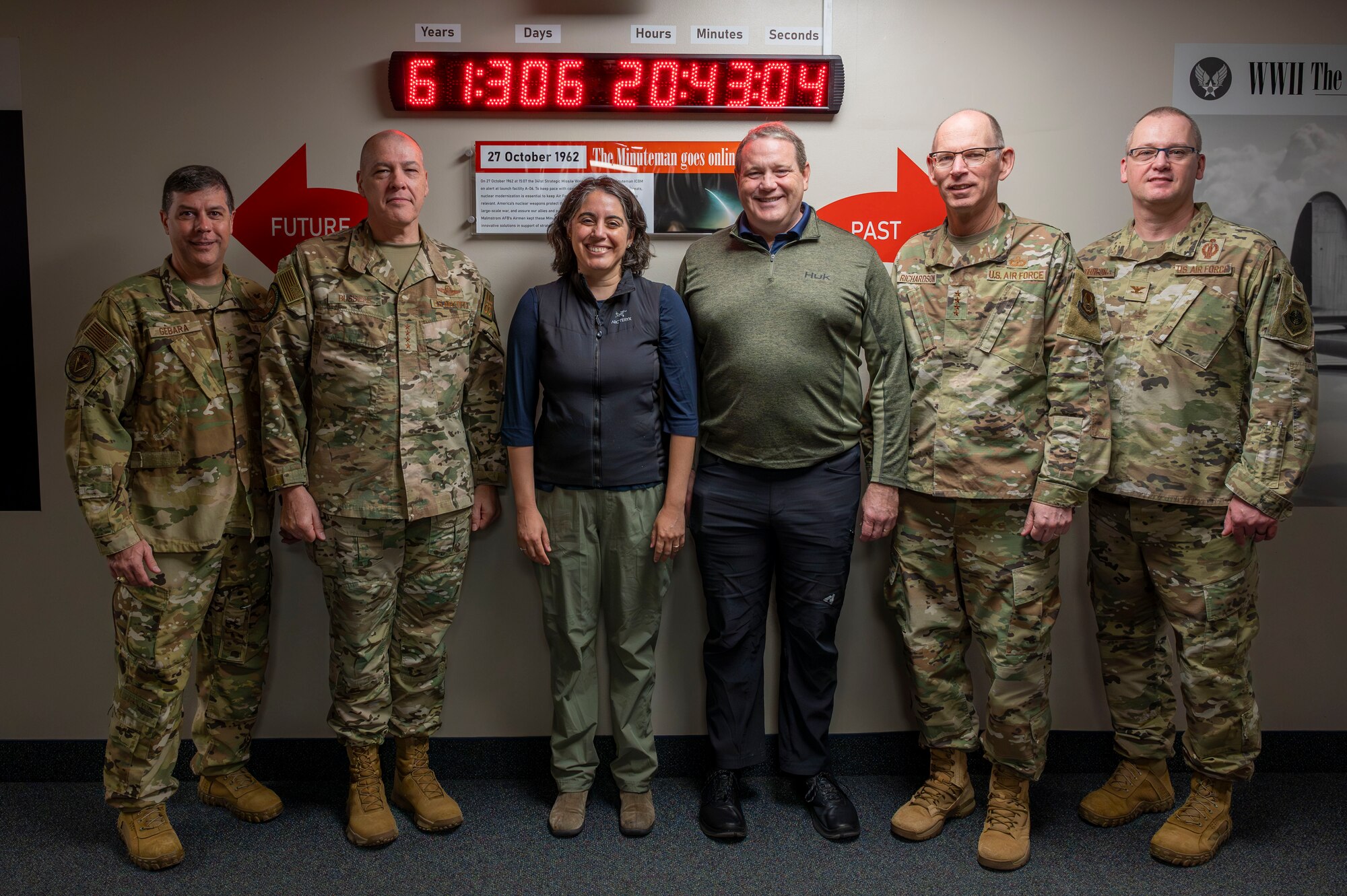 Six people posing for a picture in front or a countdown clock.
