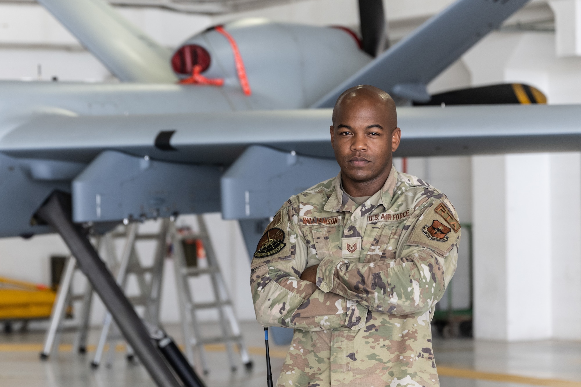 U.S. Air Force Tech. Sgt. Jeremy Williamson, 491st Attack Squadron flight expeditor, poses for a photo in front of an MQ-9 Reaper at Hancock Field Air National Guard Base, New York.