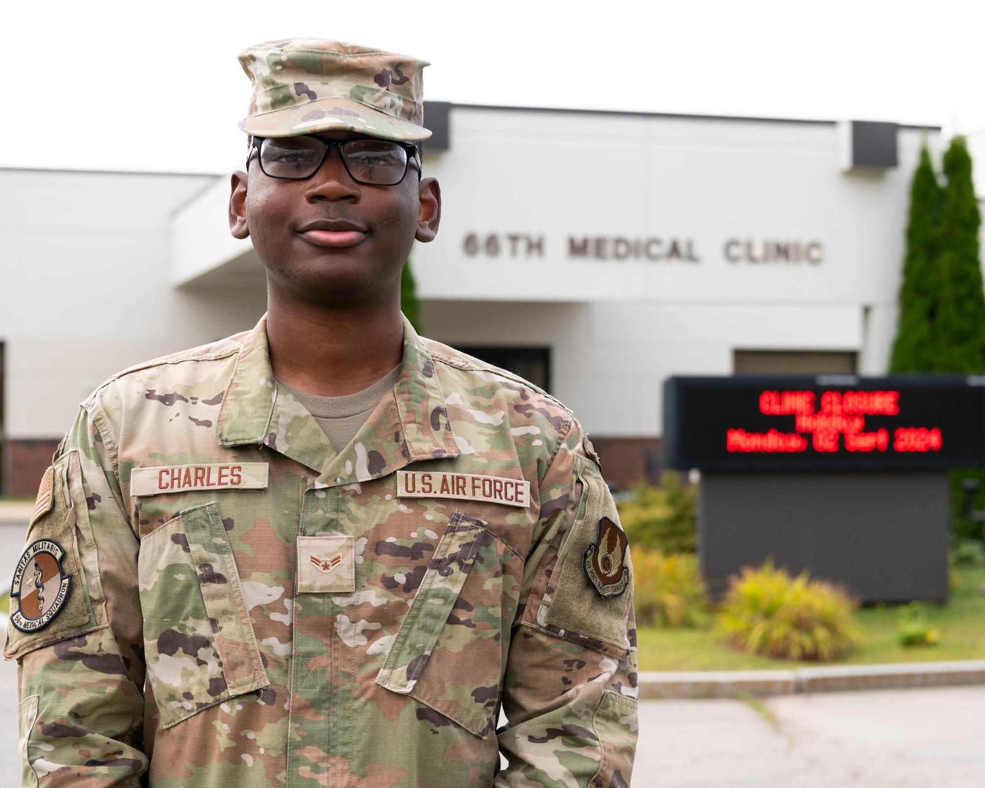 Enlisted Airman stands in front of medical clinic.