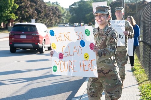 Image of Airman holding a sign with an encouraging message.