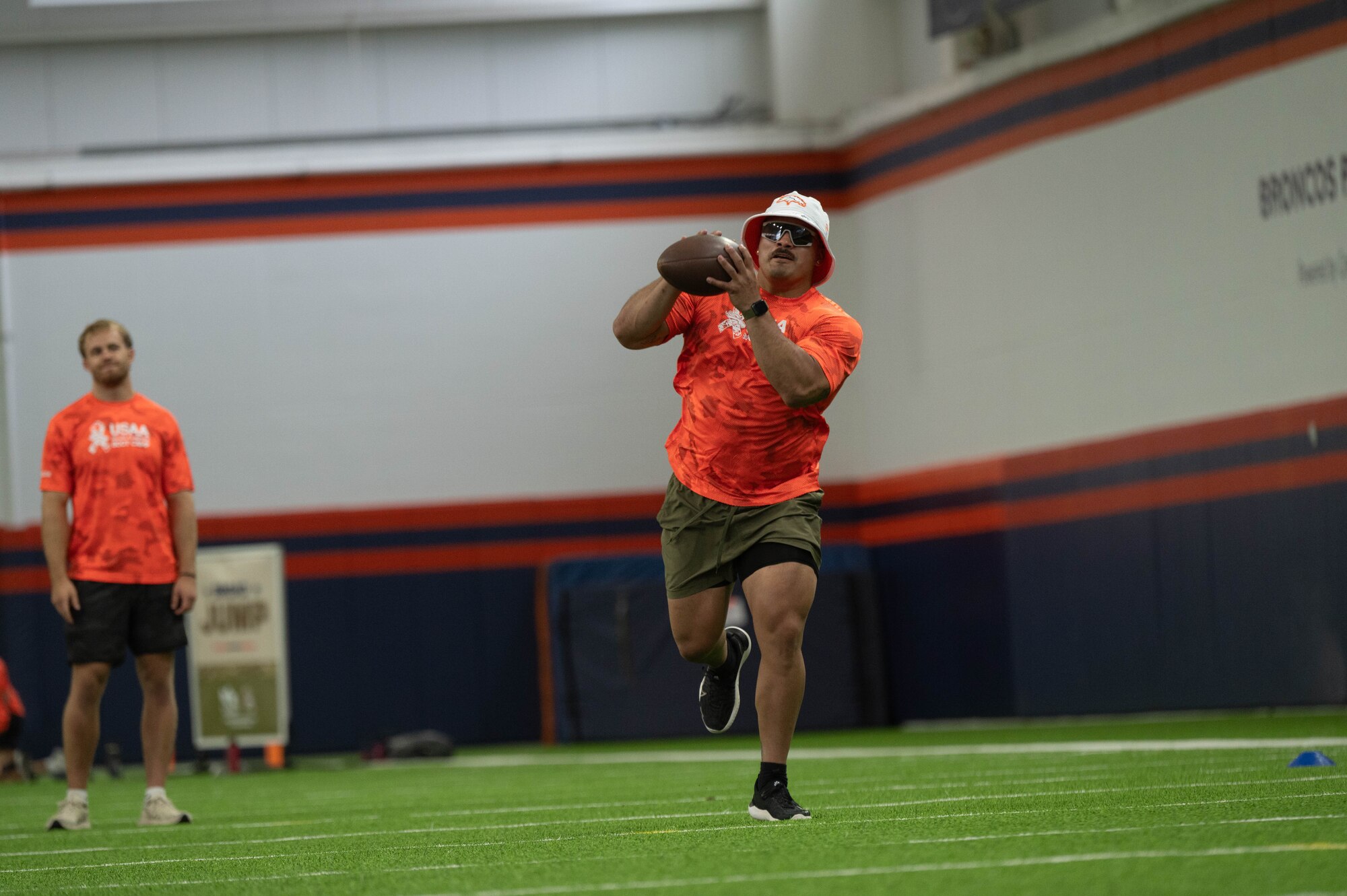 U.S. Soldier catches a football while running a 40 yards in the receiving gauntlet while that the Denver Broncos training camp.