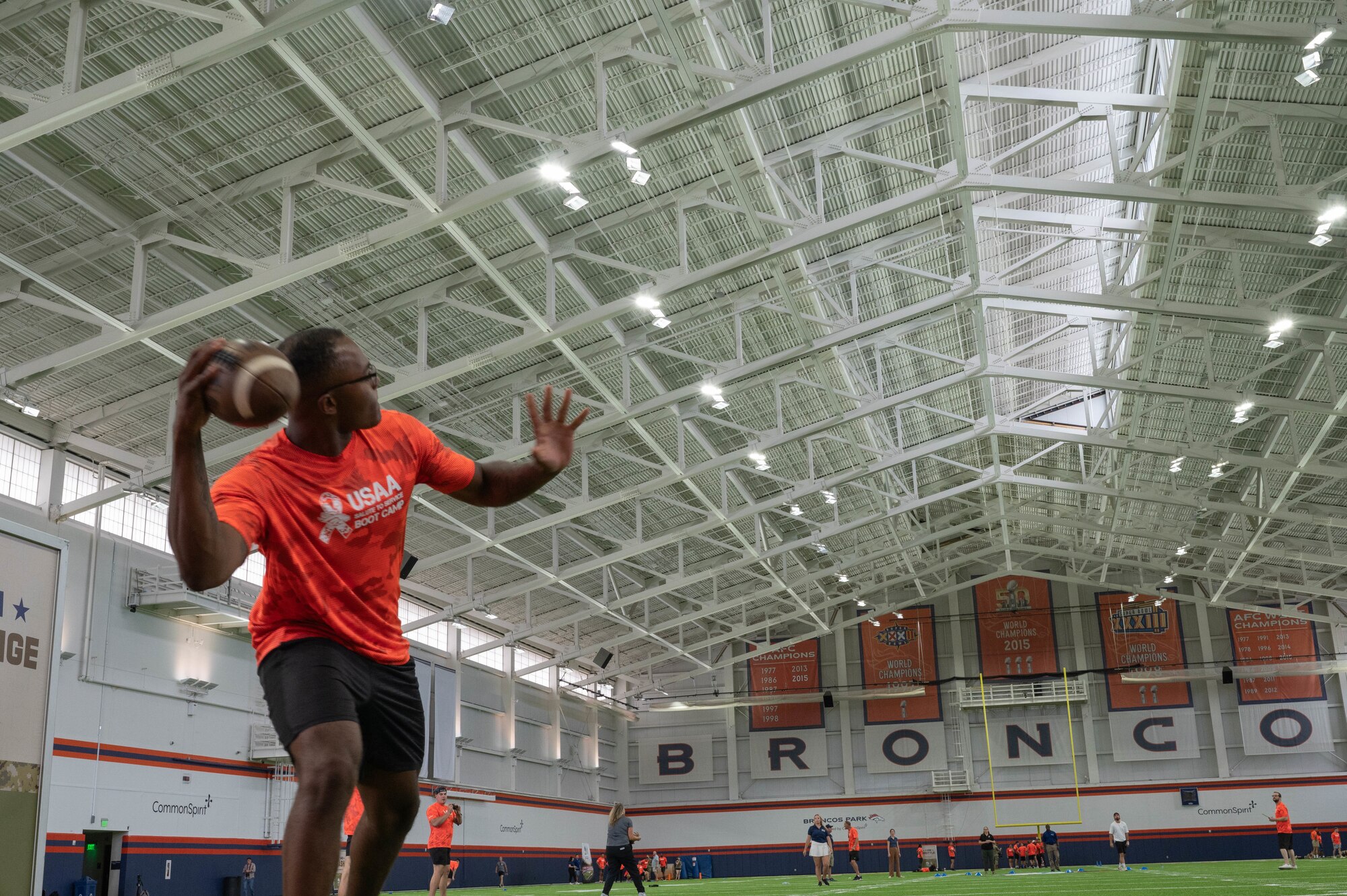U.S. service member readies to throw a football in an quarter back arm challenge event held at the Broncos training camp.