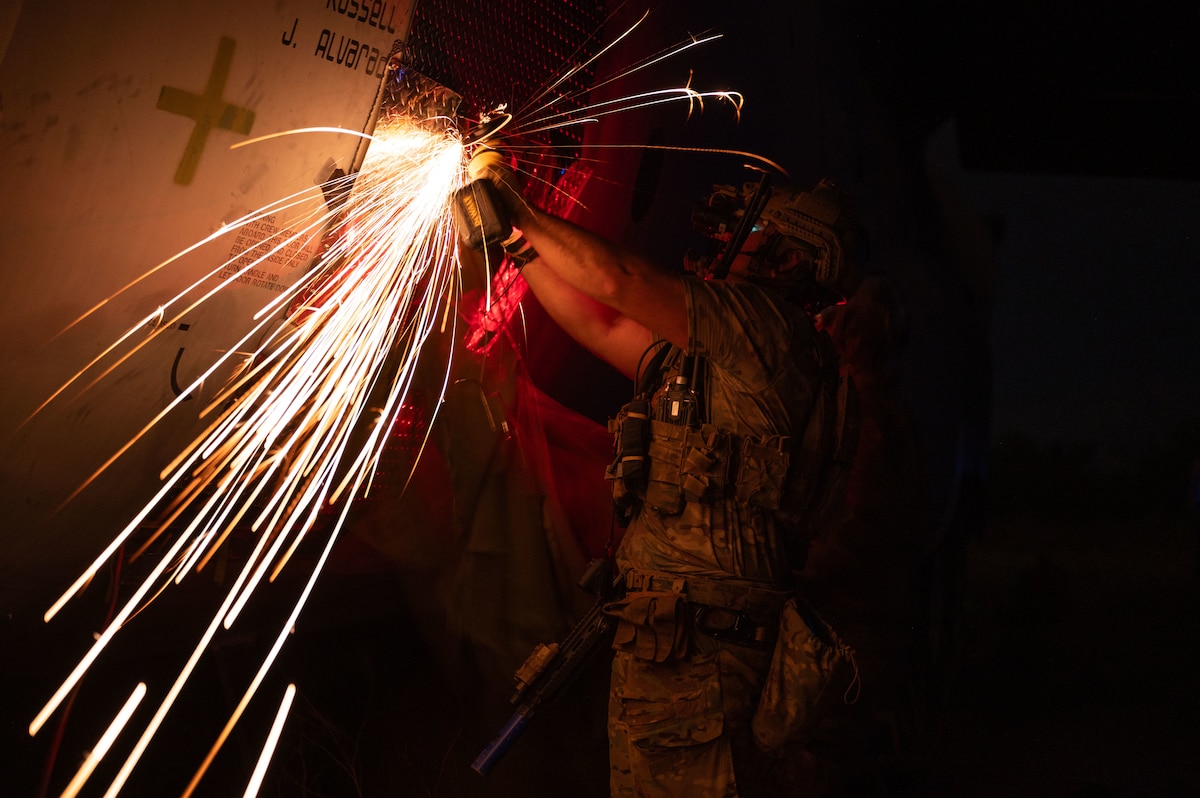 A U.S. Air Force pararescueman assigned to the 68th Rescue Squadron saws through an aircraft at Davis-Monthan Air Force Base, Arizona, Aug. 27, 2024. PJs had to cut the hull in order to extract simulated patients trapped in the aircraft. (U.S. Air Force photo by Airman 1st Class Jasmyne Bridgers-Matos)
