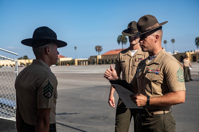U.S. Marine Corps Gunnery Sgt. Donald Vilchek, the drill master of Recruit Training Regiment, Marine Corps Recruit Depot San Diego, right, briefs Staff Sgt. Aaron Ruiz, a senior drill instructor with Lima Company, 3rd Recruit Training Battalion, prior to his final drill evaluation at MCRD San Diego, California, Aug. 24, 2024. During the final drill evaluation, the platoons are  scored based on their uniforms, bearing, and movements, as well as the senior drill instructor’s cadence, sword control, and movement commands. (U.S. Marine Corps photo by Sgt. Jesse K. Carter-Powell)