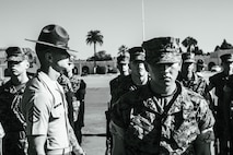 U.S. Marine Corps Staff Sgt. Jacob Landis, the drill master for 3rd Recruit Training Battalion, Recruit Training Regiment, inspects a platoon with Lima Company, 3rd Recruit Training Battalion during their final drill evaluation at Marine Corps Recruit Depot San Diego, California, Aug. 24, 2024. During the final drill evaluation, the platoons are scored based on their uniforms, bearing, and movements, as well as the senior drill instructor’s cadence, sword control, and movement commands. (U.S. Marine Corps photo illustration by Sgt. Jesse K. Carter-Powell)