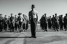 U.S. Marine Corps Gunnery Sgt. Donald Vilchek, the drill master of Recruit Training Regiment, Marine Corps Recruit Depot San Diego, left, checks the pace count of Staff Sgt. Aaron Ruiz, a senior drill instructor with Lima Company, 3rd Recruit Training Battalion, center, as part of his final drill evaluation at MCRD San Diego, California, Aug. 24, 2024. During the final drill evaluation, the platoons are scored based on their uniforms, bearing, and movements, as well as the senior drill instructor’s cadence, sword control, and movement commands. (U.S. Marine Corps photo illustration by Sgt. Jesse K. Carter-Powell)