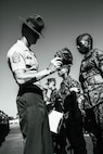 U.S. Marine Corps Staff Sgt. Jacob Landis, the drill master for 3rd Recruit Training Battalion, Recruit Training Regiment, inspects a platoon with Lima Company, 3rd Recruit Training Battalion during their final drill evaluation at Marine Corps Recruit Depot San Diego, California, Aug. 24, 2024. During the final drill evaluation, the platoons are scored based on their uniforms, bearing, and movements, as well as the senior drill instructor’s cadence, sword control, and movement commands. (U.S. Marine Corps photo illustration by Sgt. Jesse K. Carter-Powell)