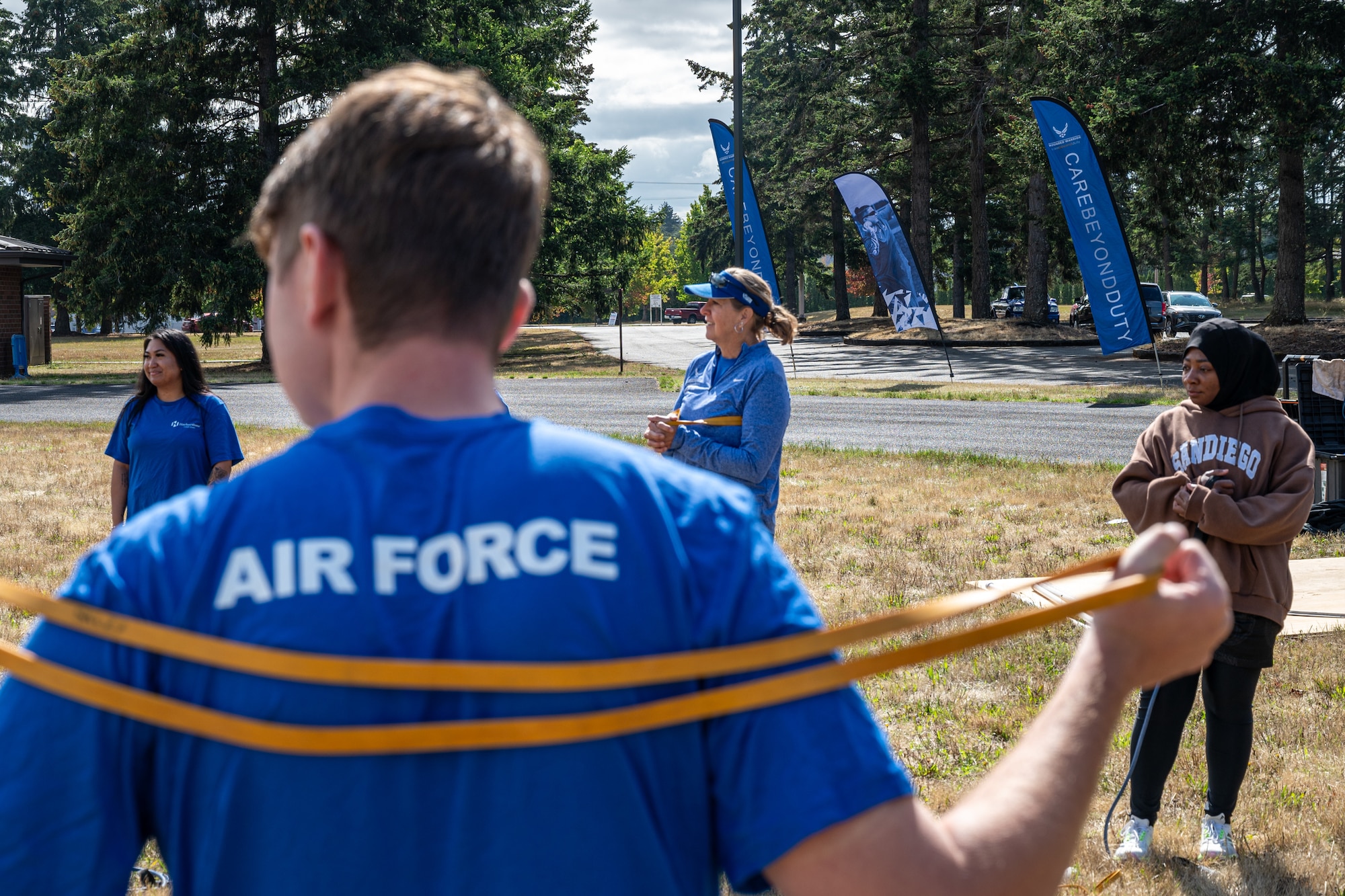 Event participants and support staff stretch with resistance bands during an Air Force Wounded Warrior event at Joint Base Lewis-McChord, Washington, Aug. 27, 2024.
