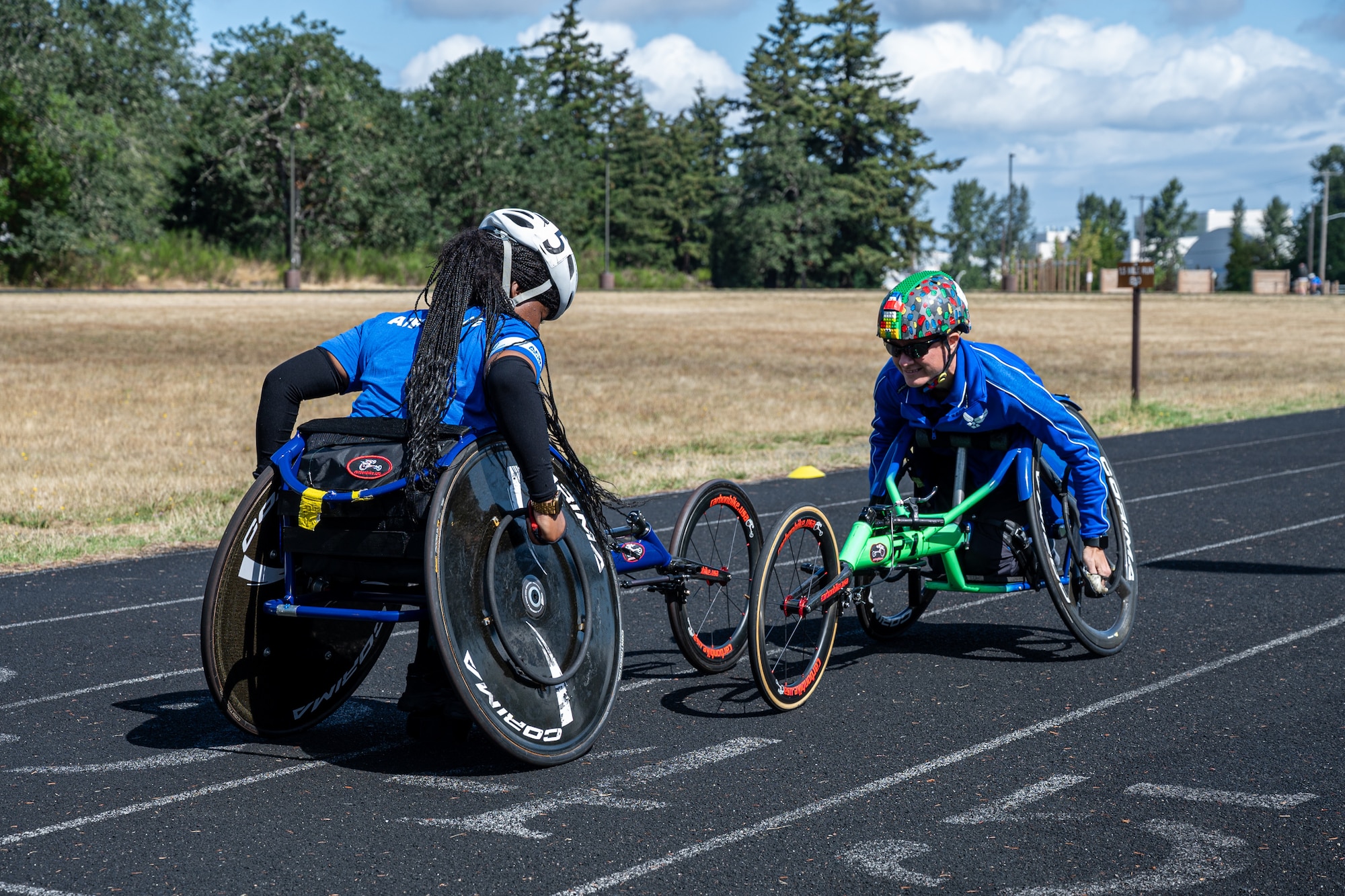 Heather Sealover, Invictus Games 2023 and Warrior Games 2024 athlete, teaches an Air Force Wounded Warrior event participant to use a racing wheelchair at Joint Base Lewis-McChord, Washington, Aug. 27, 2024.