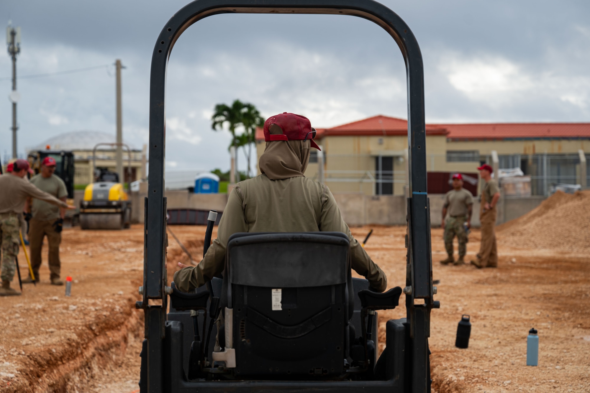 U.S. Air Force Airman Tatiana Daza, 554th Rapid Engineer Deployable Heavy Operational Repair Squadron Engineers pavements and construction equipment operator, uses a pressurized vibratory roller to smooth dirt for a K-SPAN foundation at Andersen Air Force Base, Guam, Aug. 29, 2024. A K-SPAN is a storage facility for deployable assets, which helps increase the lifetime of equipment. (U.S. Air Force photo by Senior Airman Jasmine M. Barnes)