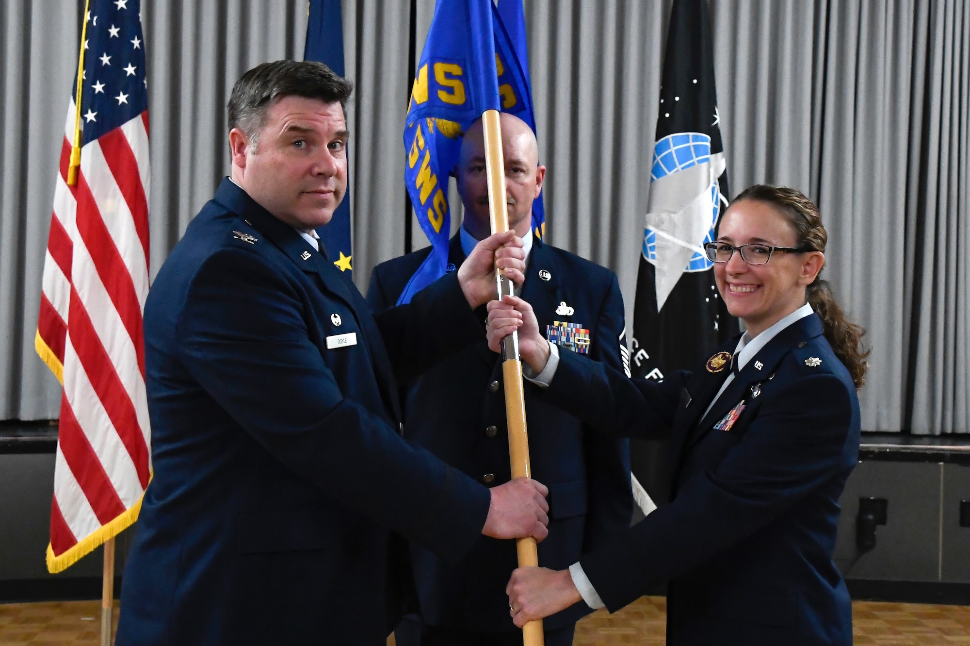 Col. Ben Doyle, 168th Operations Group commander, presents the guidon to Lt. Col. Jody Schweickart, incoming 213th Space Warning Squadron commander, during a change of command ceremony on May 21, 2024, at Clear Space Force Station.