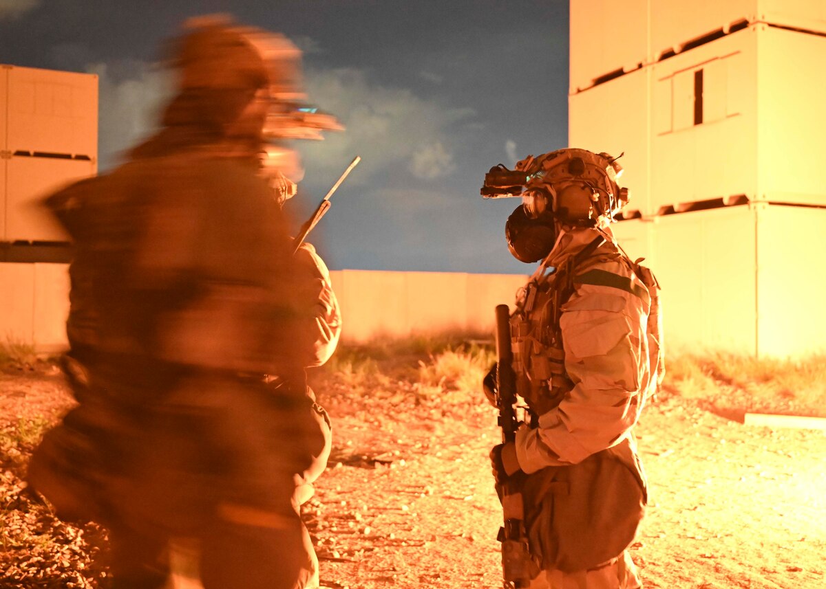 People in military uniforms next to a fire