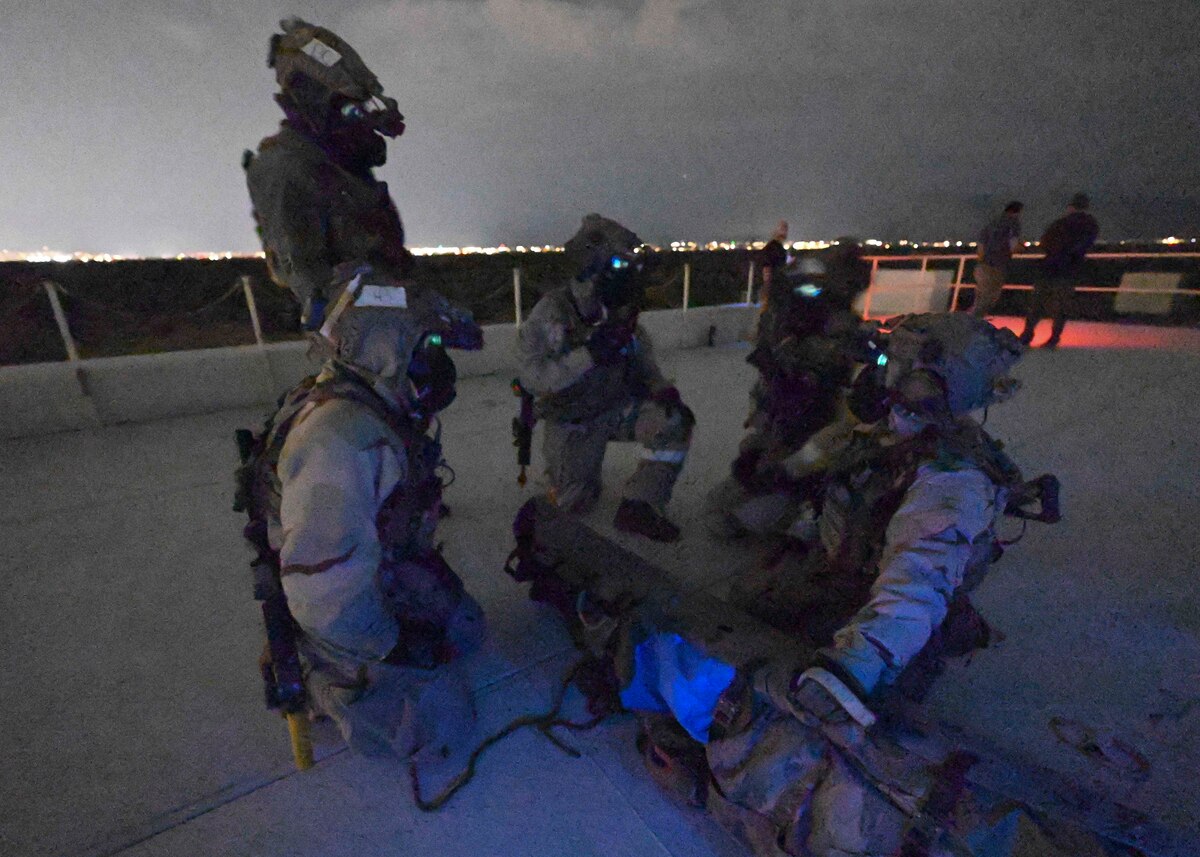 People in military uniforms talk in a group