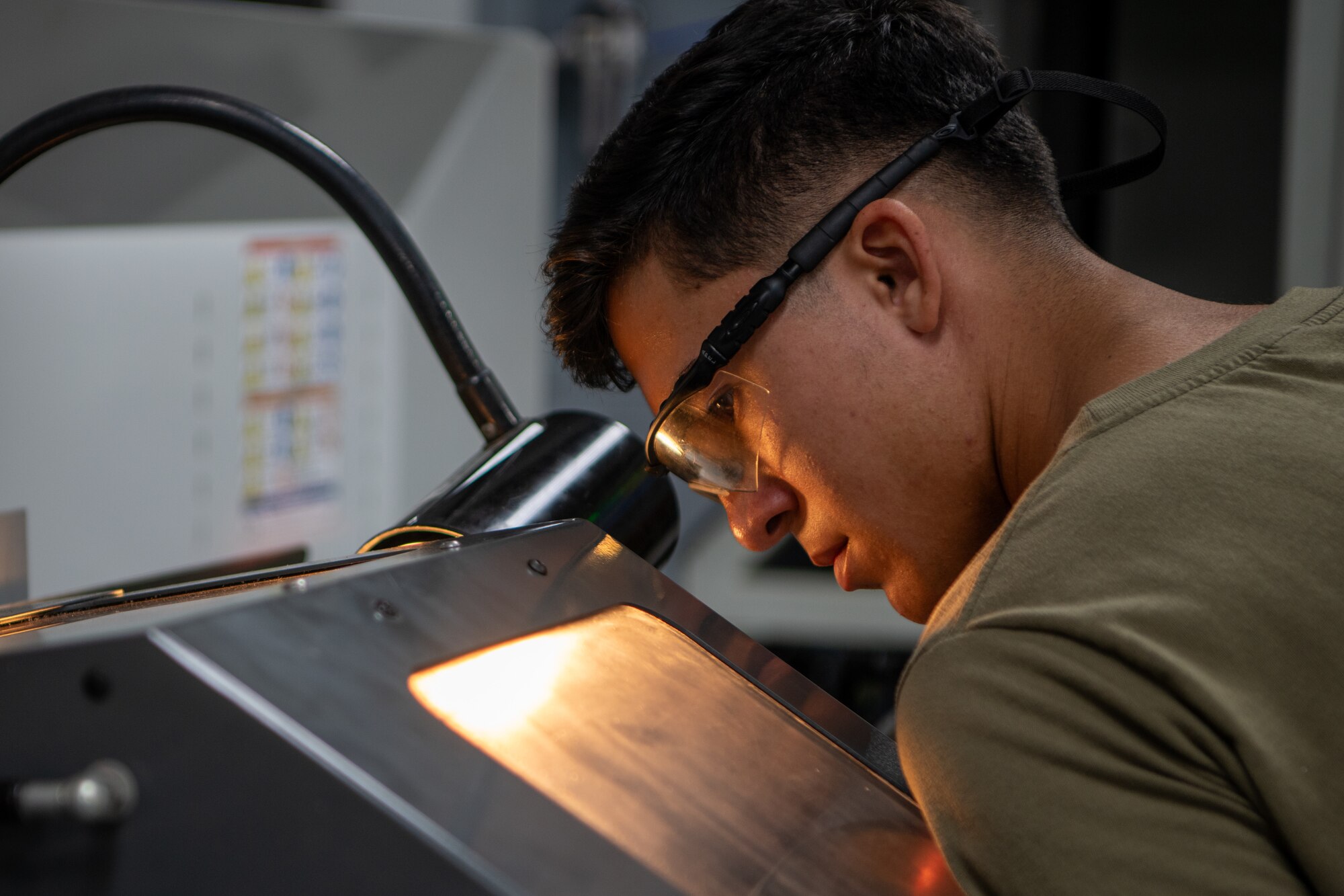 Airman monitors a lathe machine