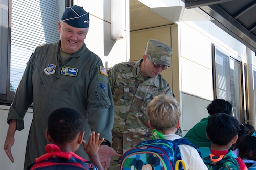 U.S. Air Force Lt. Gen. Ricky Rupp, U.S. Forces Japan and 5th Air Force commander, and Chief Master Sgt. Shaun Campbell, 5AF command chief, high-five students.