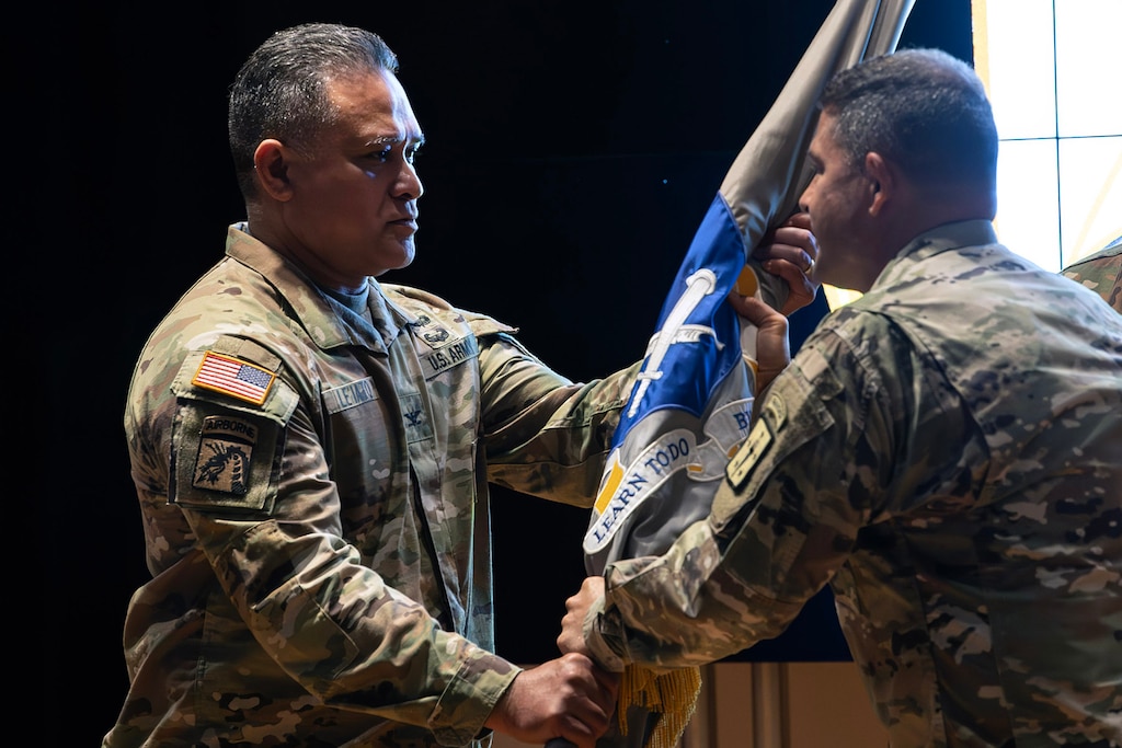 Col. Robert L. Le'iato, commandant of the Finance and Comptroller School and chief of the Finance Corps, receives the school colors from Col. Jason T. Edwards, Soldier Support Institute commander during a ceremon held in the institute's auditorium, July 30, 2024. (U.S. Army photo by Robert Timmons)