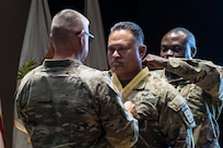 Lt. Gen. Paul A. Chamberlain, military deputy to the Assistant Secretary of the Army for Finance and Comptroller, places a medallion around the neck of Col. Robert L. Le'iato, signifying him becoming the 43rd commandant of the Finance and Comptroller School, July 30, 2024. Le'iato assumed authority for the school and became chief of the Finance Corps during a ceremony held in the Soldier Support Institute auditorium. (U.S. Army photo by Robert Timmons)