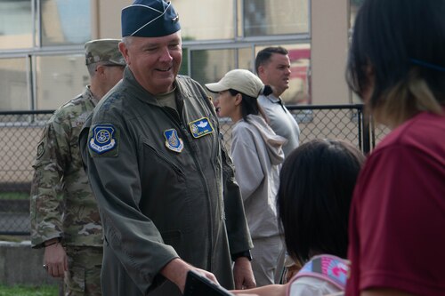 U.S. Air Force Lt. Gen. Ricky Rupp, U.S. Forces Japan and 5th Air Force commander, shakes a student’s hand.