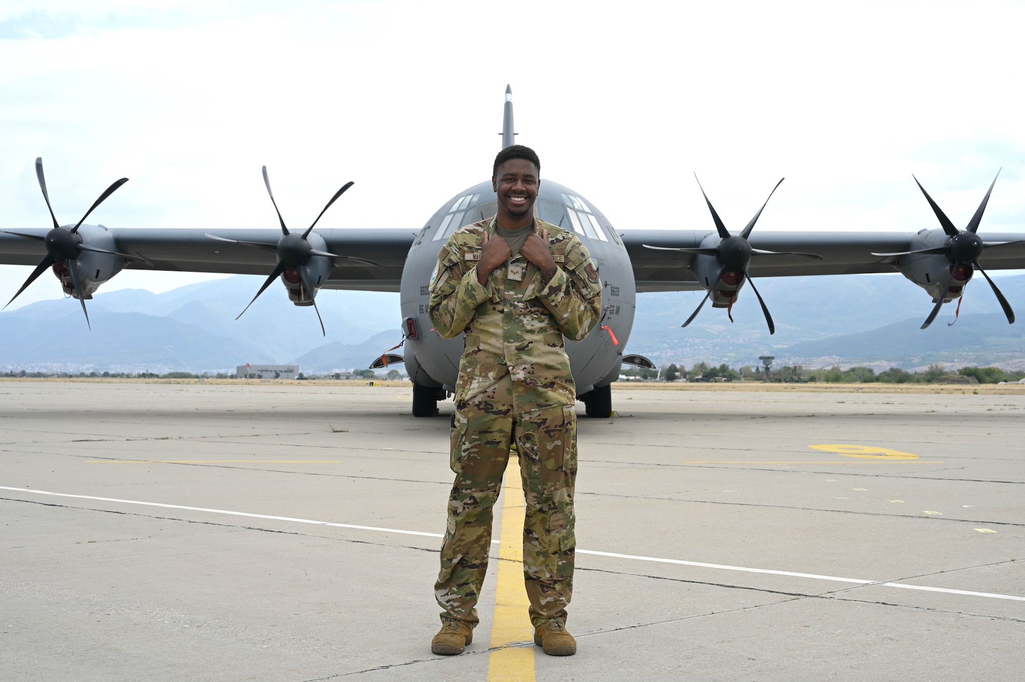 A man poses in front of a plane