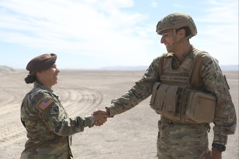 U.S. Sgt. 1st Class Monica Giraldo, assigned to the 1st Security Forces Assistance Brigade, greets a Chilean soldier during Southern Fenix 24 (SF24) on Aug. 28, 2024 near Campo Militar Pozo, Almonte, Chile.