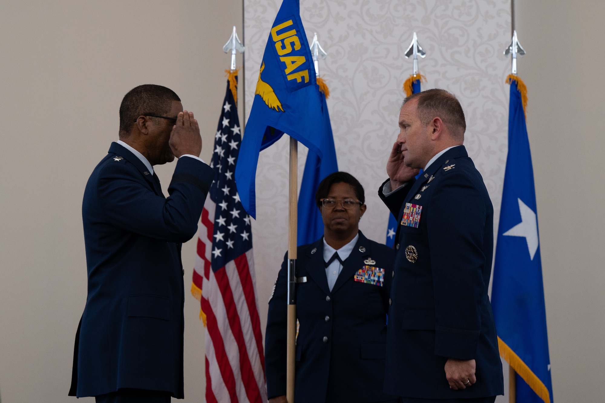 Reed and Arrington salute each other as Hert holds the guidon behind them.