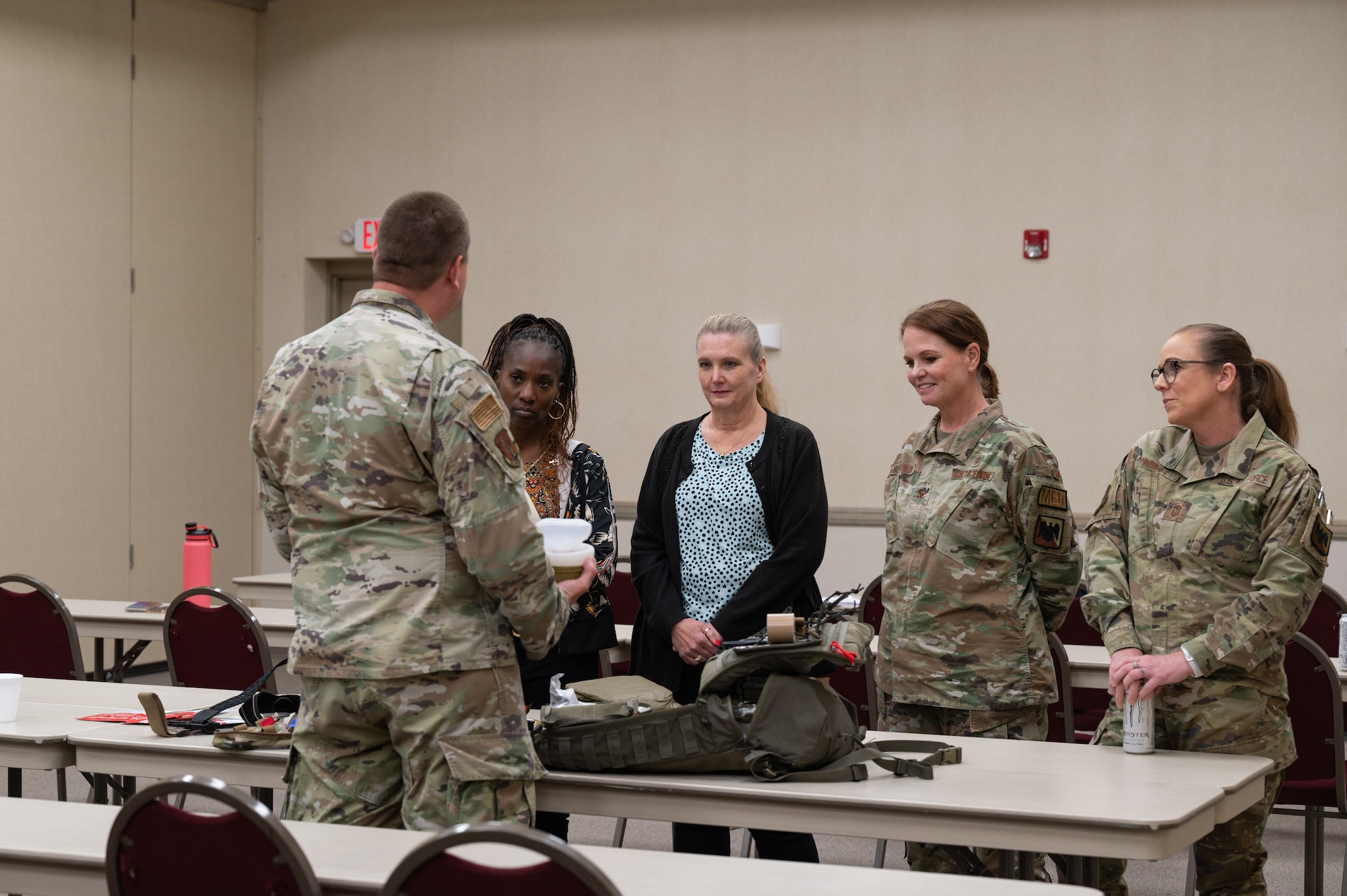From right: U.S. Air Force Chief Master Sgt. Janet Probst, chief medical enlisted force, National Guard Bureau Surgeon's Office (NGB-SG); Col. Linda A. Rohatsch, director, Medical Service Office of the Air Surgeon, Air National Guard; Laura Wedding, chief, budget and resource division, NGB-SG; and Paula McCauley, chief, resource management branch, NGB-SG; all listen to Chief Master Sgt. Thomas Wastart, superintendent, aerospace medicine, NGB-SG, as he explains the contents of an M-10 medical backpack while attending a Medical Readiness University training event at Alpena Combat Readiness Training Center, Alpena, Michigan, June 13, 2024. This large-scale training event provided Total Force Airmen with hands-on and real-world operational training at a reduced cost for more than 21 medical career specialties. (U.S. Air National Guard photo by Tech. Sgt. Sarah M. McClanahan)
