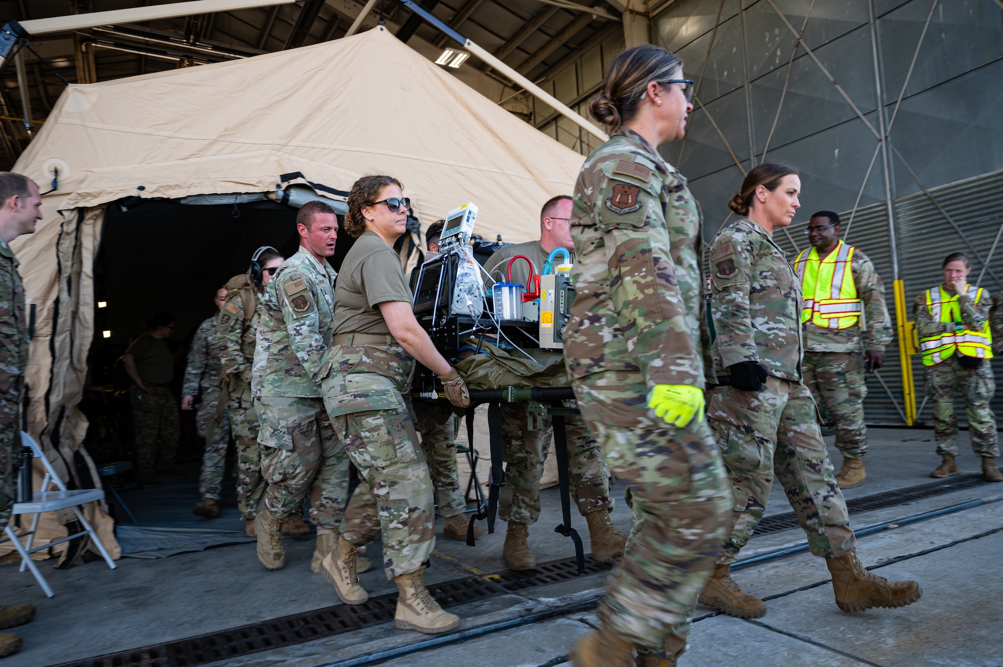 U.S. Air Force medical Airmen transport a simulated patient on a special medical emergency evacuation device (SMEED) platform during a Medical Readiness University capstone exercise at Alpena Combat Readiness Training Center, Alpena, Michigan, June 13, 2024. During the capstone exercise, critical care air transport team Airmen familiarized themselves with SMEED equipment to practice quickly and efficiently securing vital equipment to litters during mass casualty scenarios. (U.S. Air National Guard photo by Tech. Sgt. Sarah M. McClanahan)