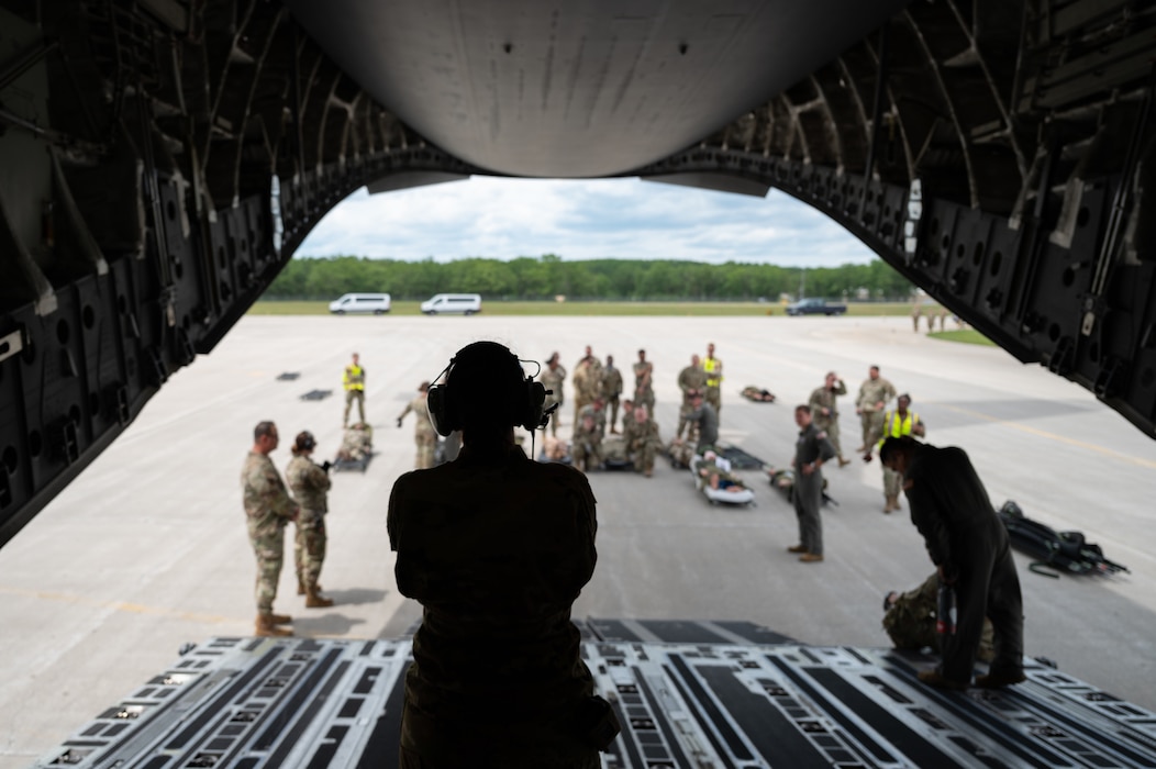 U.S. Air Force Capt. Alexandra Cunningham, center, flight nurse, 445th Airlift Wing, Wright-Patterson Air Force Base, controls the flow of movement of simulated patients, personnel, and equipment on a C-17A Globemaster III aircraft during a Medical Readiness University capstone exercise at Alpena Combat Readiness Training Center, Alpena, Michigan, June 13, 2024. This large-scale training event provided Total Force Airmen with hands-on and real-world operational training at a reduced cost for more than 21 medical career specialties. (U.S. Air National Guard photo by Tech. Sgt. Sarah M. McClanahan)