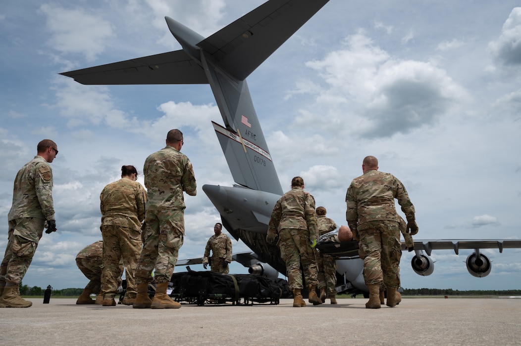 U.S. Airmen load simulated patients onto a U.S. Air Force C-17A Globemaster III aircraft assigned to the 445th Airlift Wing, Wright-Patterson Air Force Base, during a Medical Readiness University capstone exercise at Alpena Combat Readiness Training Center, Alpena, Michigan, June 13, 2024. This large-scale training event provided Total Force Airmen with hands-on and real-world operational training at a reduced cost for more than 21 medical career specialties. (U.S. Air National Guard photo by Tech. Sgt. Sarah M. McClanahan)