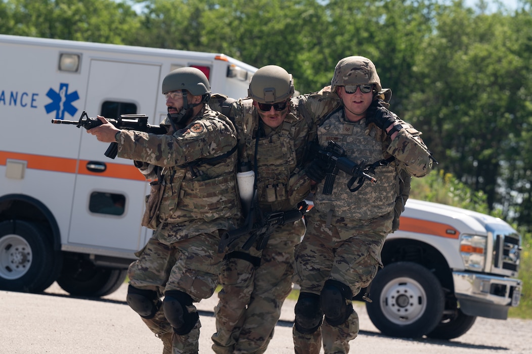 U.S. Air Force medical Airmen with the Air National Guard transport a simulated casualty using a two-man carry during a Medical Readiness University capstone exercise at Alpena Combat Readiness Training Center, Alpena, Michigan, June 13, 2024. This large-scale training event provided Total Force Airmen with hands-on and real-world operational training at a reduced cost for more than 21 medical career specialties. (U.S. Air National Guard photo by Tech. Sgt. Sarah M. McClanahan)