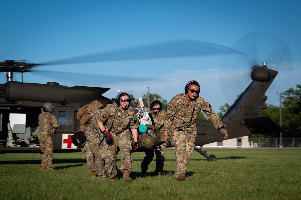 U.S. Air Force medical Airmen on a critical care air transport team offload a simulated patient from an U.S. Army UH-60 Black Hawk helicopter assigned to Detachment 1, Company C, 3rd Battalion, 238th Aviation Regiment, Michigan National Guard, during a Medical Readiness University capstone exercise at Alpena Combat Readiness Training Center, Alpena, Michigan, June 13, 2024. This large-scale, training event provided hands-on and real-world operational training at a reduced cost for more than 300 service members from across the Joint and Total Force, including more than 21 medical career specialties, that may not be acquired elsewhere. (U.S. Air National Guard photo by Tech. Sgt. Sarah M. McClanahan)