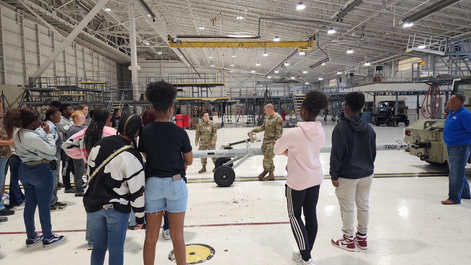 Airman explains job duties and equipment to high school students.