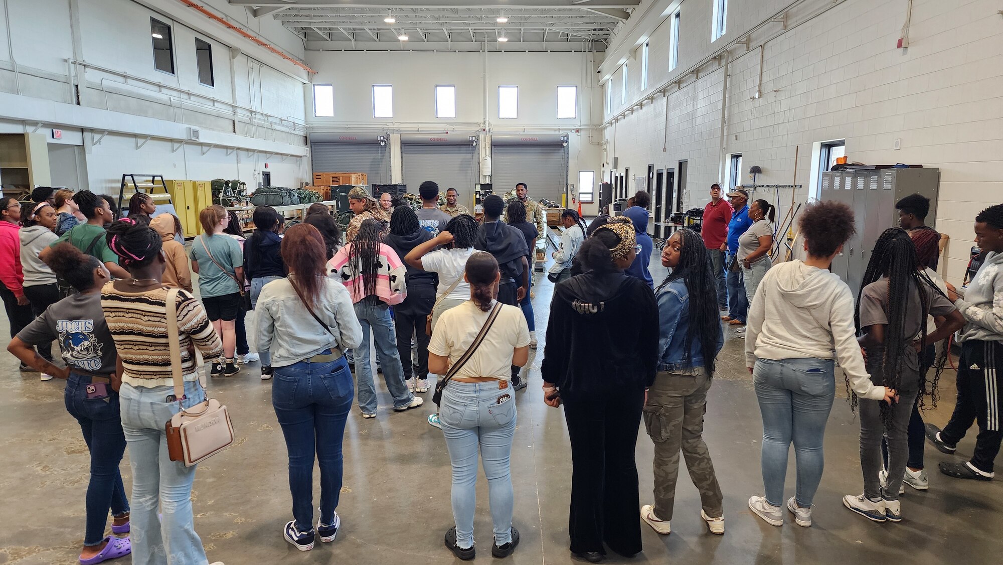 Airman explains job duties and equipment to high school students.