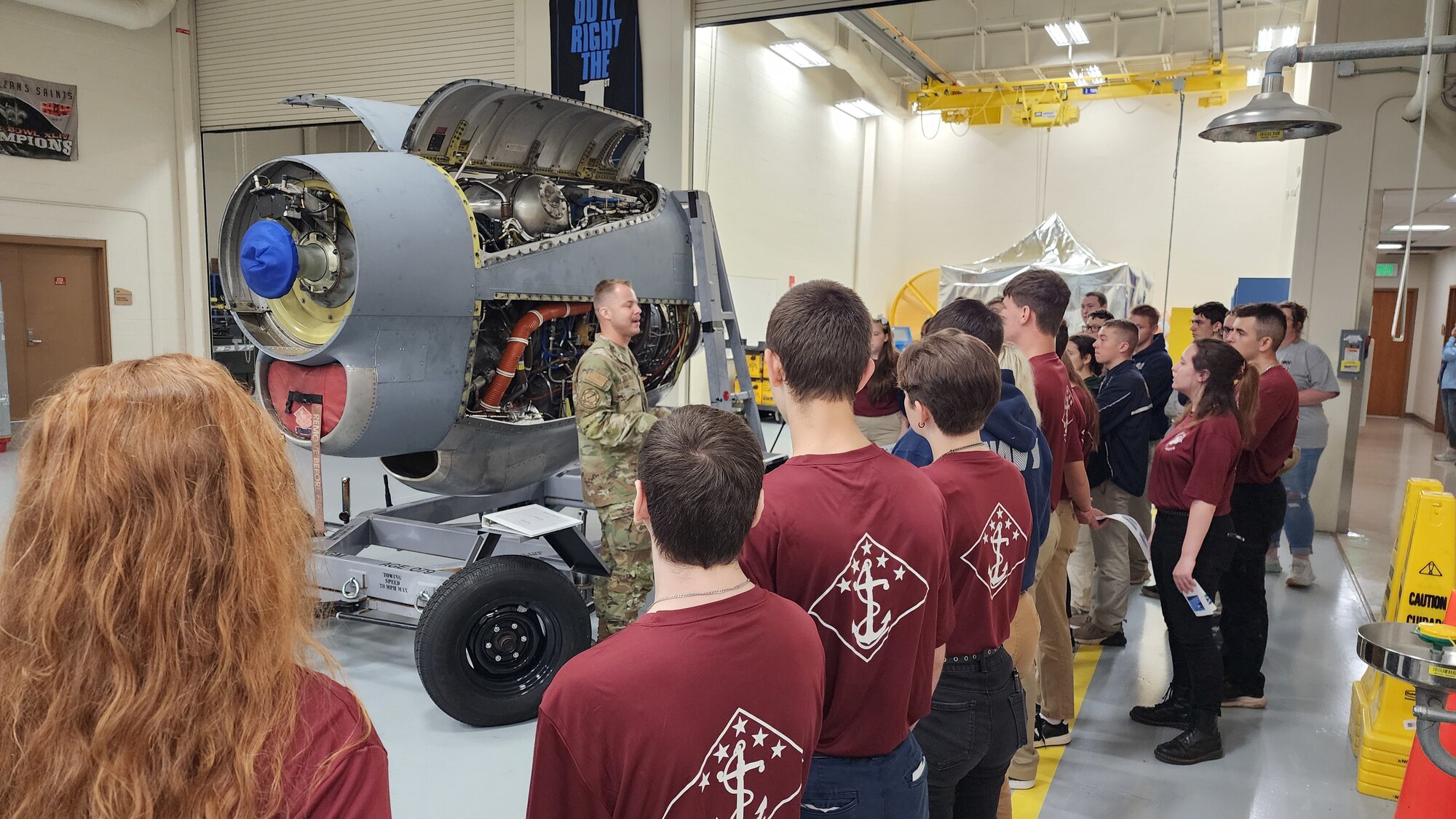 Airman explains job duties and equipment to high school students.