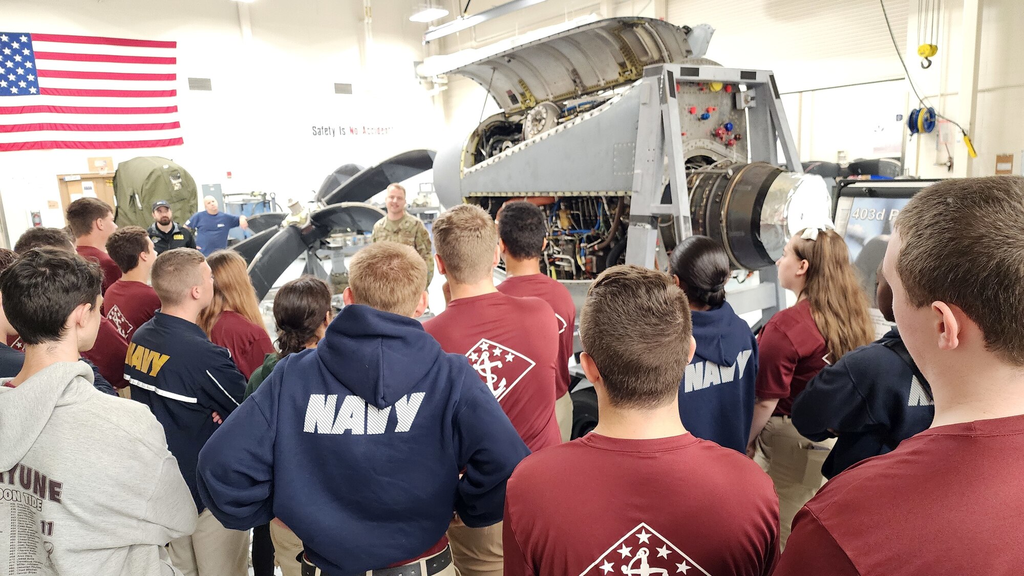 Airman explains job duties and equipment to high school students.