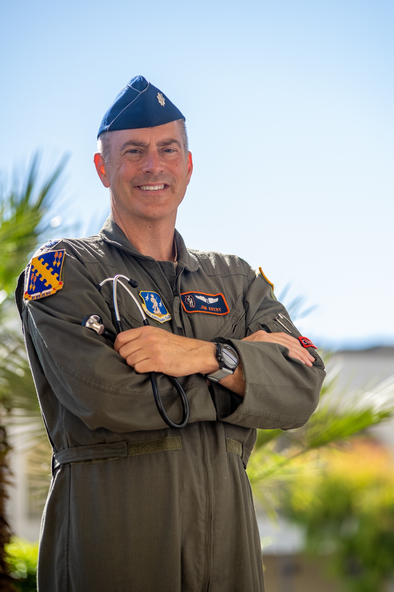 A U.S. Air Force flight surgeon poses for a photo wearing a flight suit and holding a stethoscope.