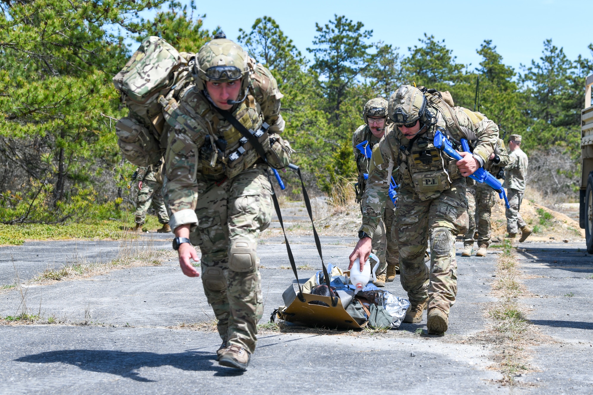 103rd Rescue Squadron pararescuemen, assigned to the New York Air National Guard 106th Rescue Wing, pull a patient toward the evacuation location during a personnel recovery exercise at F.S. Gabreski Air National Guard Base, N.Y., May 4, 2024. During the multifaceted exercise, 106th Security Forces Squadron secured the area for the 103rd Rescue Squadron pararescuemen to parachute in, recover the injured personnel, provide medical care and transport via a HH-130J Combat King II search and rescue aircraft flown by the 102nd Rescue Squadron. (U.S. Air National Guard photo by Tech Sgt. Daniel H. Farrell)