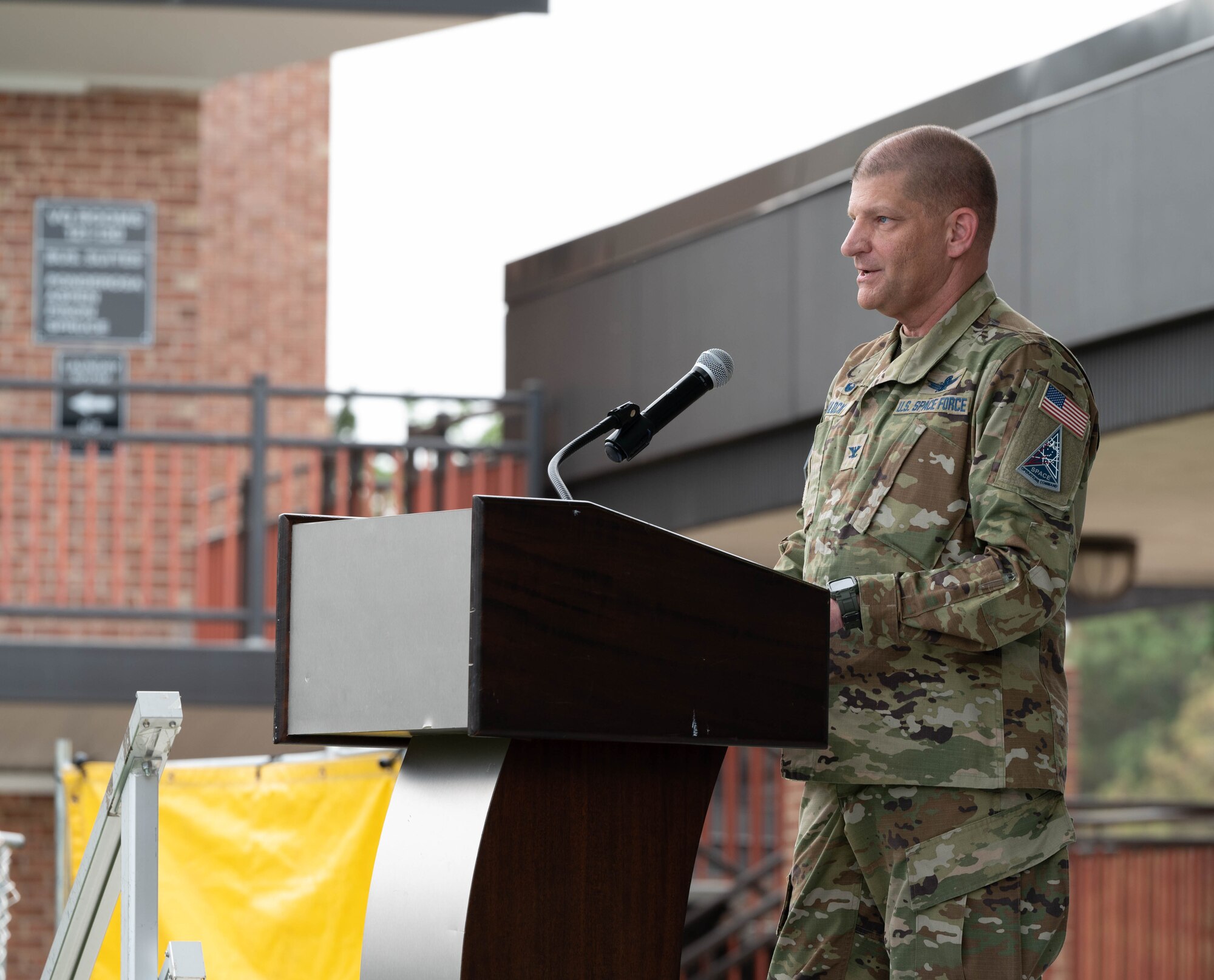 Col. Klock is standing behind a podium providing closing remarks for Resilience Day/Sports Day.
