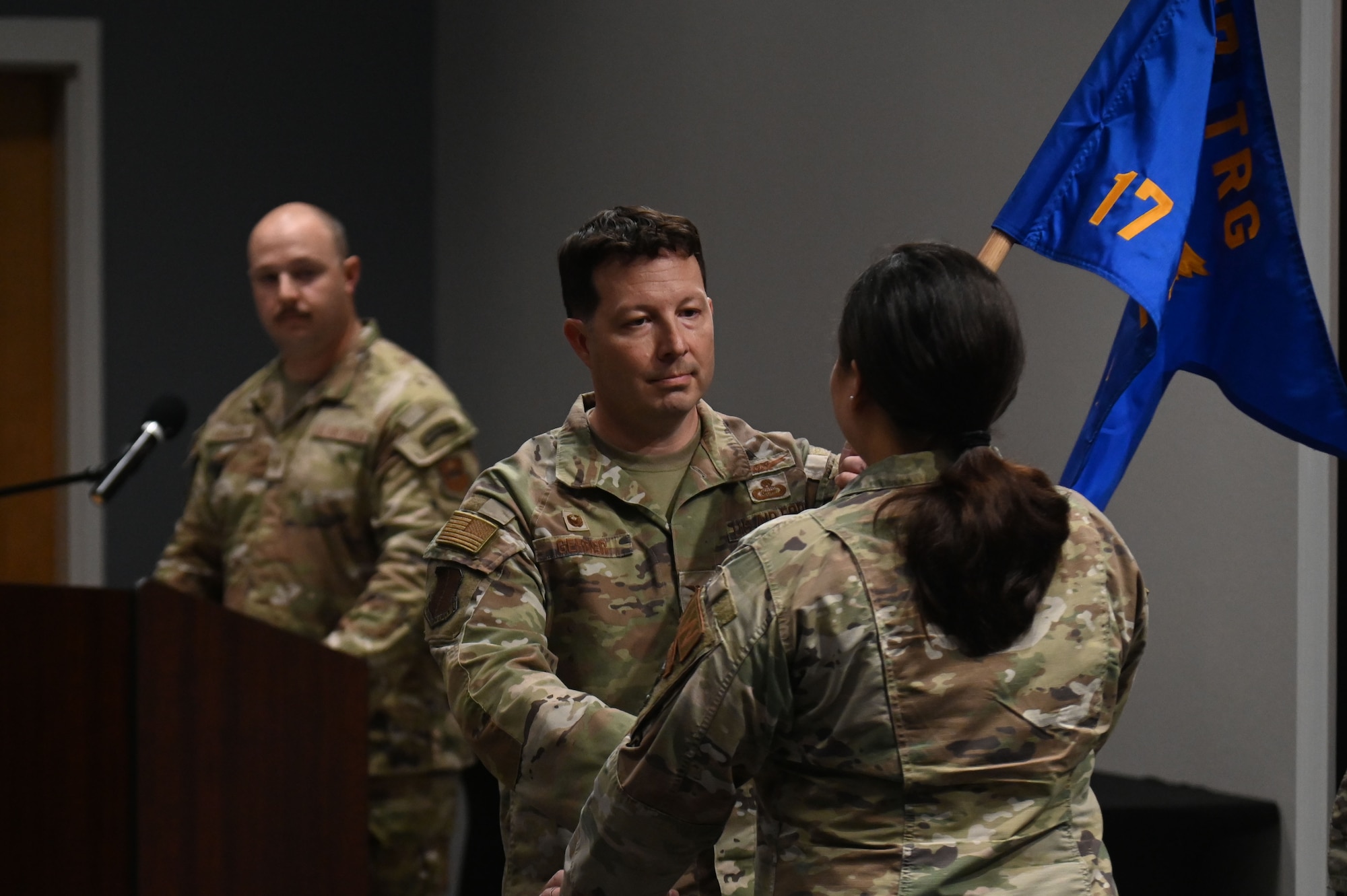 Col. Jason Gerber, 17th Training Group commander passes off the guidon to Lt. Col. Nancy Schwab, incoming 17th Training Support Squadron commander, as part of the assumption of command ceremony at the Powell Event Center, Goodfellow Air Force Base, Sep. 4, 2024. The 17th TRSS's mission is to deliver unequaled support to forge world-class joint and coalition fire protection and intelligence, surveillance and reconnaissance warriors. (U.S. Air Force photo by Airman 1st Class James Salellas)