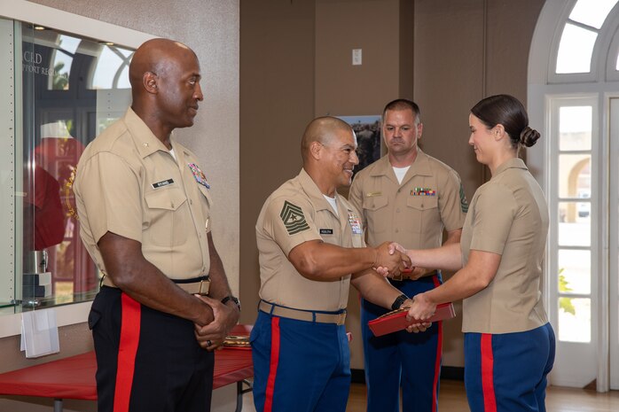 U.S. Marine Corps Brig. Gen. James A Ryan II, the commanding general of Marine Corps Recruit Depot San Diego, left, and Sgt. Maj. Carlos R. Aguilera, sergeant major of Headquarters and Service Battalion, center, congratulate an officer with the Marine Corps Recruiting Command who is being recognized for her outstanding performance and diligent efforts of the Western Recruiting Region Recruiting Offensive “Operation Overlord” at MCRD San Diego, California, Aug. 1, 2024. Operation Overlord was a summer recruiting offensive held to foster competition amongst the recruiting force and increase productivity, while creating a contracting momentum for fiscal year 2025.  (U.S. Marine Corps photo by Cpl. Sarah M. Grawcock)