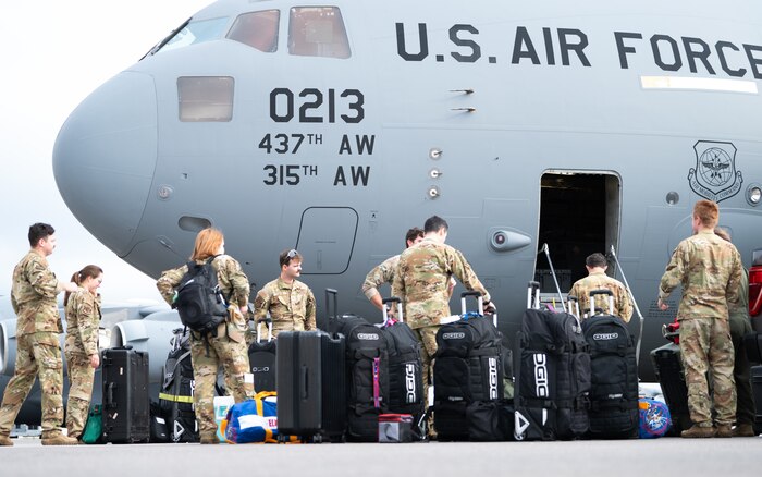 Airmen load up on a airplane.